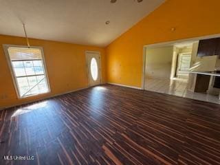 unfurnished living room with dark hardwood / wood-style flooring and high vaulted ceiling