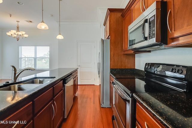 kitchen with a sink, visible vents, brown cabinets, and stainless steel appliances