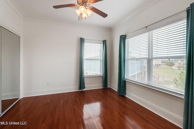 unfurnished room with dark wood finished floors, baseboards, crown molding, and a ceiling fan