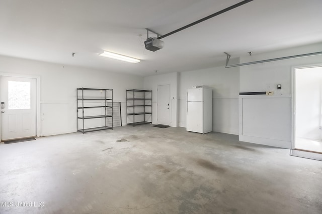 garage featuring a garage door opener and freestanding refrigerator