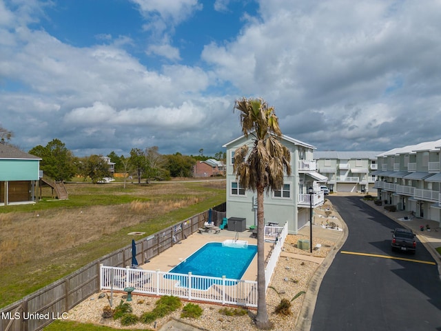 view of swimming pool with a patio area, a residential view, a fenced in pool, and a fenced backyard