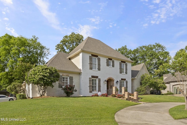 colonial house with brick siding, roof with shingles, and a front yard