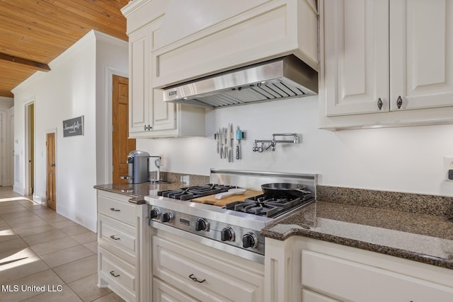 kitchen with stainless steel gas cooktop, light tile patterned floors, white cabinets, and wooden ceiling