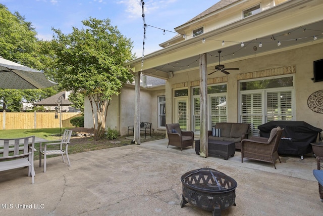 view of patio / terrace with ceiling fan, fence, and an outdoor living space with a fire pit