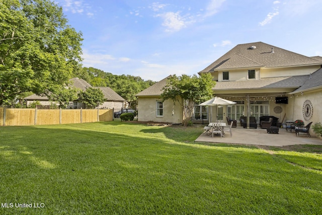 back of property featuring fence, a yard, a patio, a shingled roof, and stucco siding
