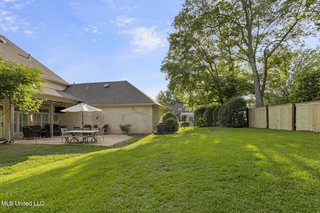 view of yard featuring fence, a patio area, and central AC