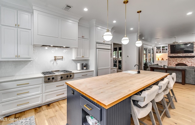 107 Chadwyck Ct, Madison, MS 39110 - kitchen with wooden counters, stainless steel gas cooktop, open floor plan, an island with sink, and paneled fridge