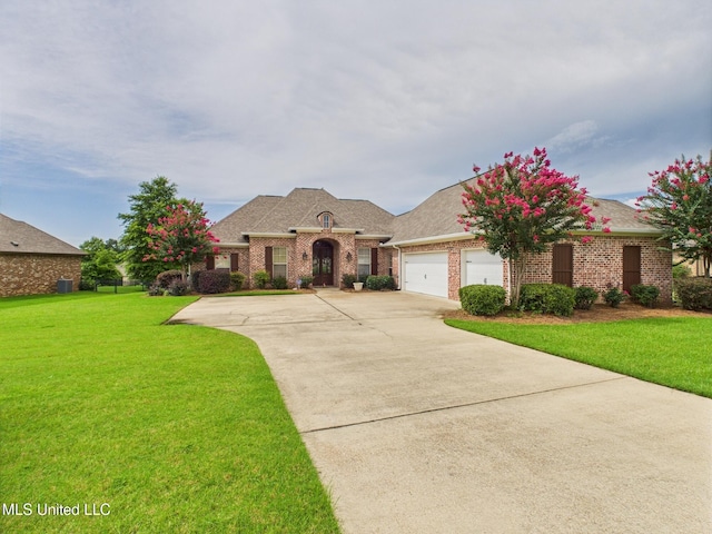 143 Charlton Dr, Madison, MS 39110 - french country style house with a front yard, brick siding, an attached garage, concrete driveway, and roof with shingles