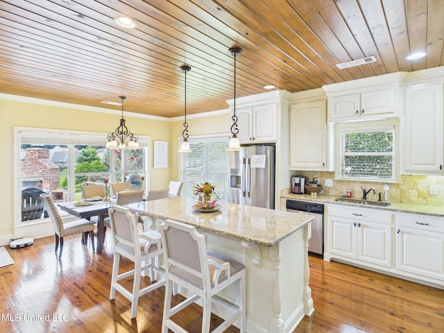 143 Charlton Dr, Madison, MS 39110 - kitchen with stainless steel appliances, wood ceiling, white cabinets, pendant lighting, and a kitchen island