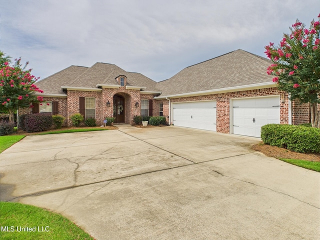 143 Charlton Dr, Madison, MS 39110 - french country home with brick siding, roof with shingles, concrete driveway, and an attached garage
