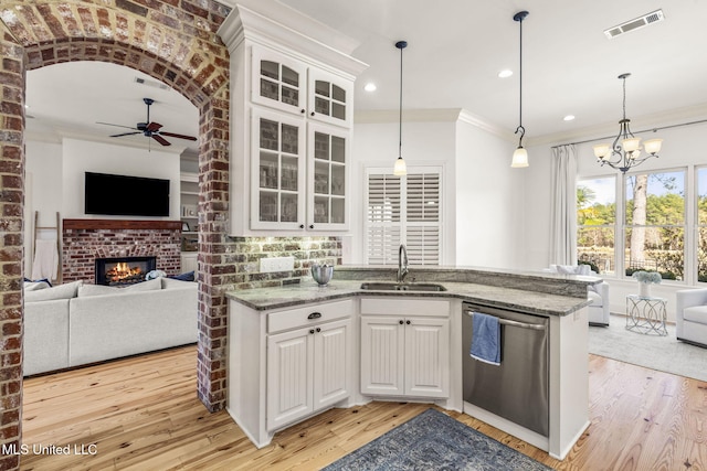 kitchen with light wood-style floors, open floor plan, a sink, and stainless steel dishwasher