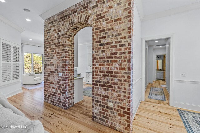 corridor featuring arched walkways, hardwood / wood-style floors, recessed lighting, and crown molding