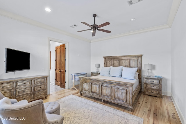 bedroom featuring light wood-type flooring, visible vents, ornamental molding, and baseboards