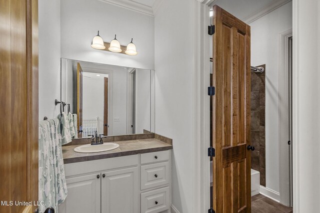 full bath with tile patterned floors, crown molding, and vanity