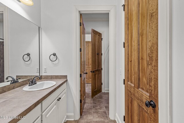 bathroom featuring tile patterned flooring, vanity, and baseboards