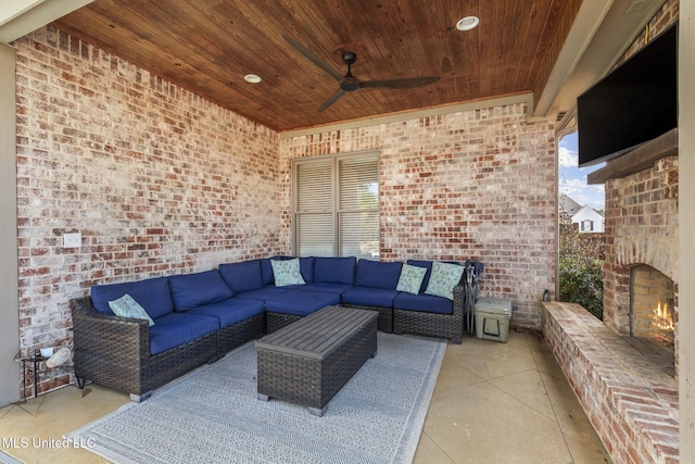 view of patio with ceiling fan and an outdoor living space with a fireplace