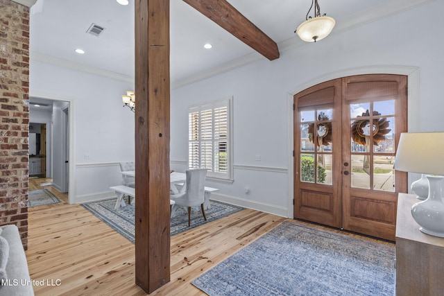 foyer entrance featuring visible vents, arched walkways, hardwood / wood-style flooring, beamed ceiling, and french doors