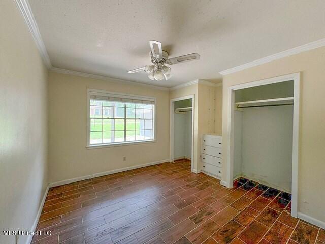 305 Longview St, Vicksburg, MS 39180 - unfurnished bedroom with ceiling fan, baseboards, two closets, and ornamental molding