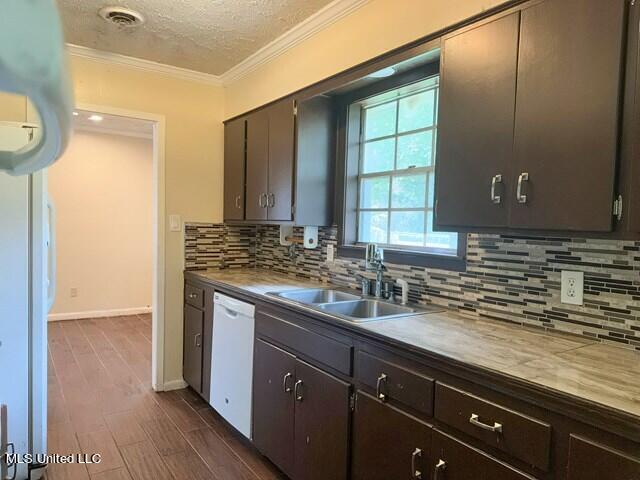 305 Longview St, Vicksburg, MS 39180 - kitchen with dark wood-style floors, a sink, a textured ceiling, white dishwasher, and ornamental molding