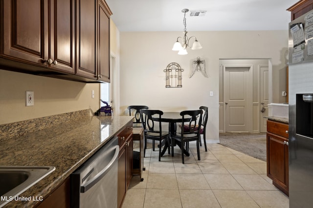 18496 Devin Ct, Gulfport, MS 39503 - kitchen with dishwasher, a chandelier, dark stone countertops, hanging light fixtures, and light tile patterned floors