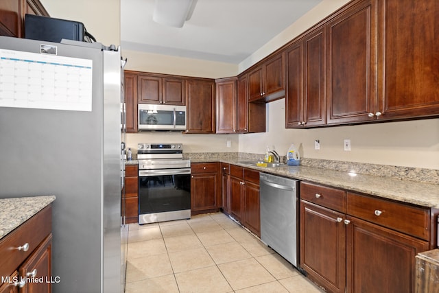 18496 Devin Ct, Gulfport, MS 39503 - kitchen featuring appliances with stainless steel finishes, light tile patterned flooring, and light stone counters