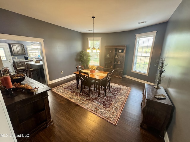 590 Eubanks Rd, Alligator, MS 38720 - dining room featuring a chandelier, dark wood finished floors, and baseboards