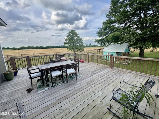 590 Eubanks Rd, Alligator, MS 38720 - wooden deck with outdoor dining space, an outdoor structure, a shed, a view of countryside, and a yard