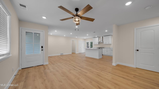 unfurnished living room featuring light wood-type flooring and ceiling fan