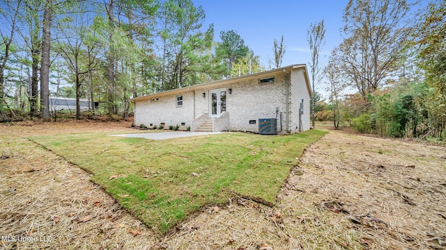 rear view of house featuring a lawn, central AC, and a patio