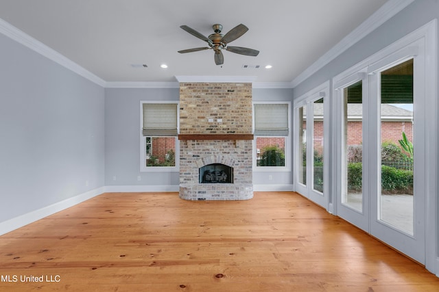 unfurnished living room featuring a fireplace, ornamental molding, light wood-type flooring, and ceiling fan