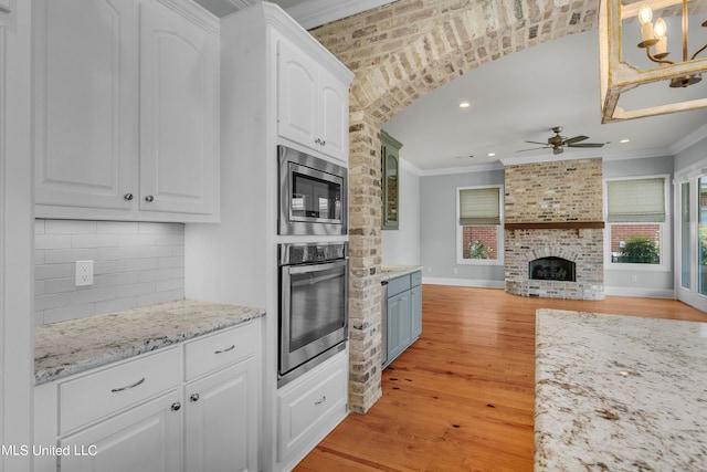 kitchen featuring white cabinets, stainless steel appliances, and light wood-type flooring