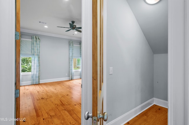 corridor with crown molding, wood-type flooring, and plenty of natural light