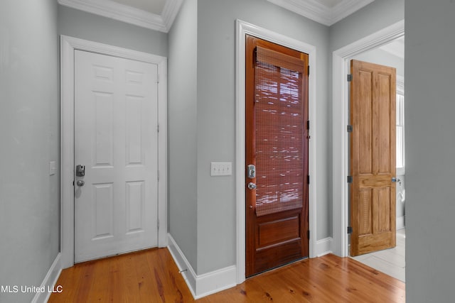 foyer featuring ornamental molding and light wood-type flooring