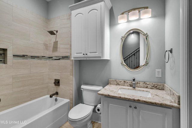 full bathroom featuring vanity, tiled shower / bath combo, and toilet