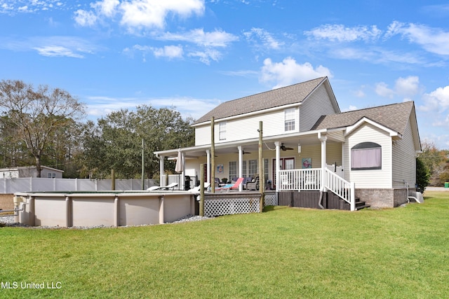 rear view of house featuring a swimming pool side deck, a yard, and ceiling fan