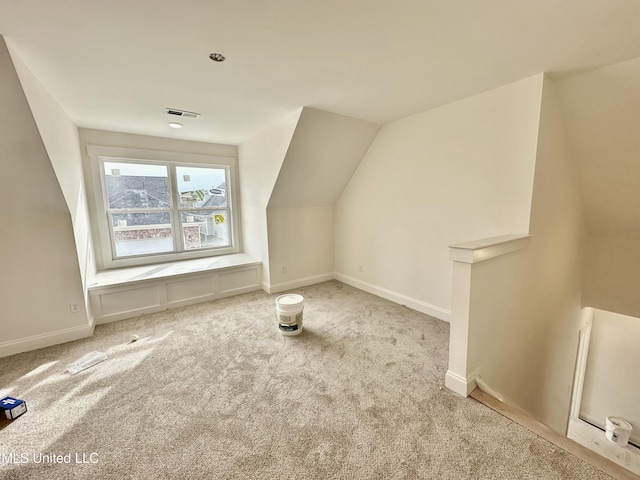 additional living space with vaulted ceiling and light carpet