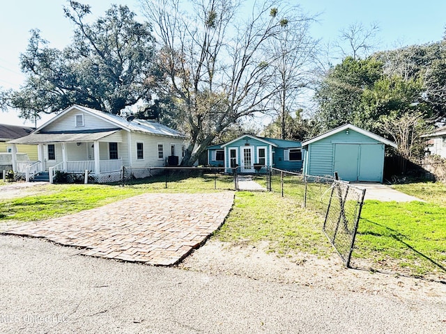 ranch-style house featuring a porch, a storage unit, and a front lawn