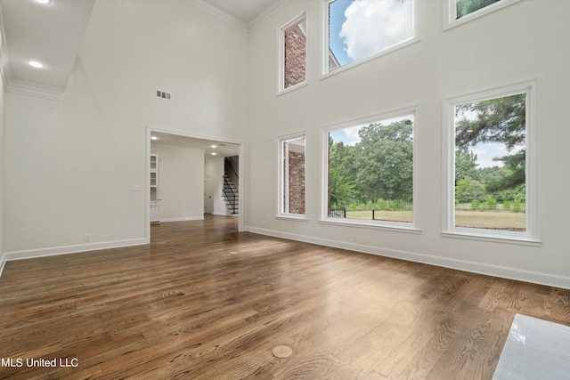 1594 Victoria Rd, Byhalia, MS 38611 - unfurnished living room with crown molding, stairway, baseboards, wood finished floors, and a towering ceiling