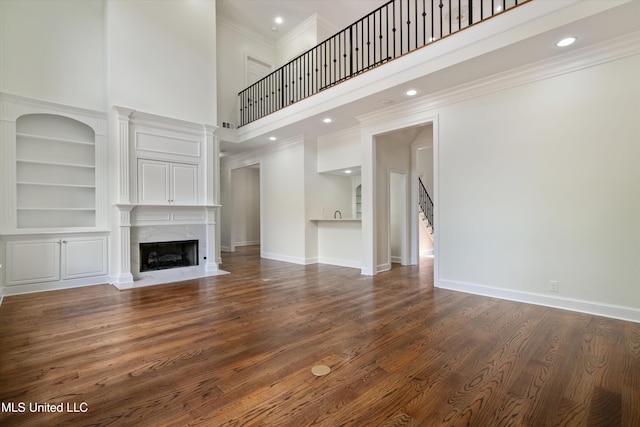 1594 Victoria Rd, Byhalia, MS 38611 - unfurnished living room with a towering ceiling, a premium fireplace, stairway, wood finished floors, and crown molding