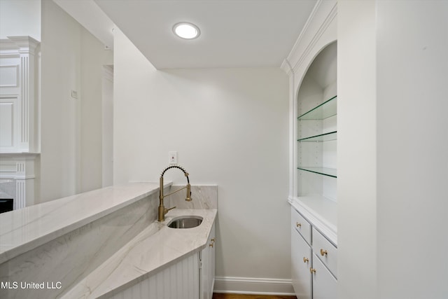 1594 Victoria Rd, Byhalia, MS 38611 - bar area featuring a sink, built in shelves, baseboards, and wood finished floors