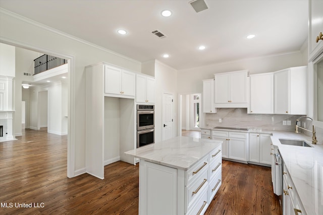 1594 Victoria Rd, Byhalia, MS 38611 - kitchen with a sink, double oven, decorative backsplash, light stone counters, and white cabinetry