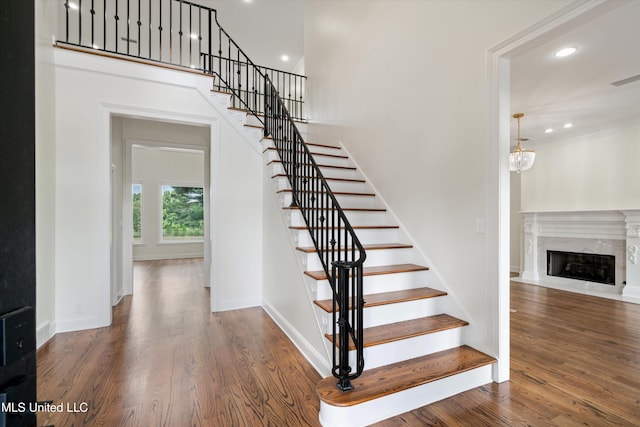 1594 Victoria Rd, Byhalia, MS 38611 - staircase featuring wood finished floors, recessed lighting, a fireplace, baseboards, and crown molding