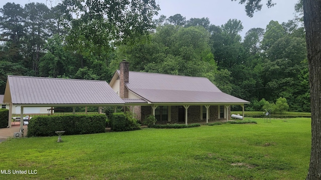 2257 Boyd Rd, Utica, MS 39175 - view of front facade featuring a front lawn, a chimney, metal roof, and driveway