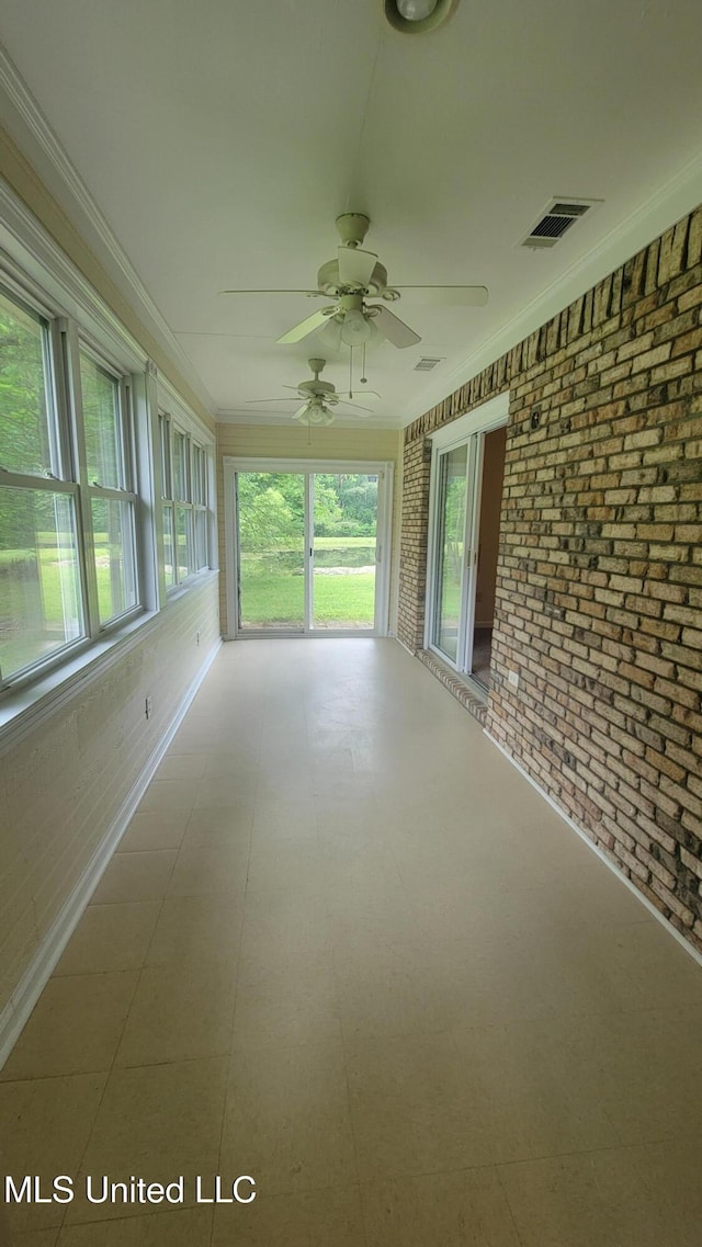 2257 Boyd Rd, Utica, MS 39175 - unfurnished sunroom with brick wall, a ceiling fan, ornamental molding, and tile patterned floors