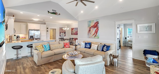 living area featuring lofted ceiling, visible vents, dark wood finished floors, and wainscoting