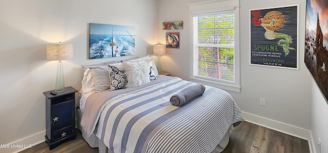 bedroom featuring baseboards and dark wood finished floors