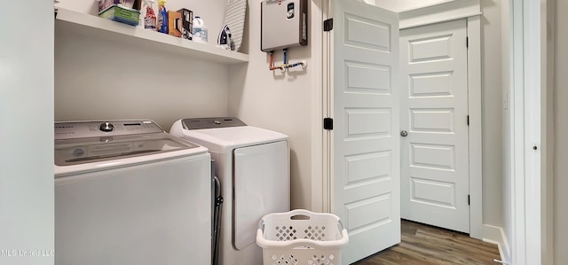 laundry area with water heater, laundry area, washing machine and dryer, and dark wood finished floors