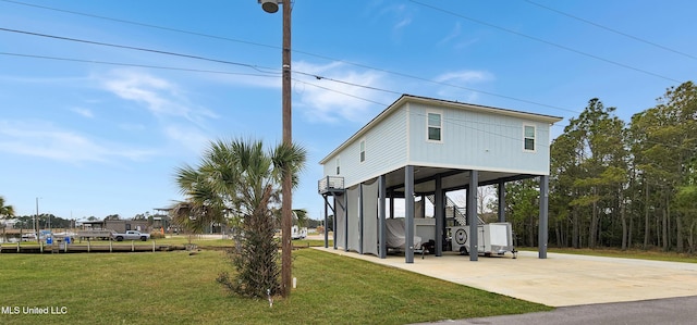 exterior space with a carport, a yard, and driveway