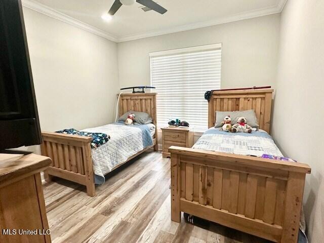 bedroom with ceiling fan, ornamental molding, and light hardwood / wood-style floors