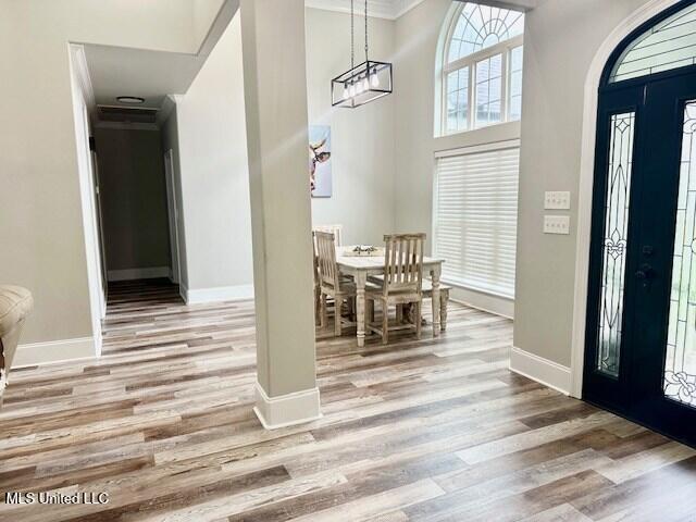 entryway with crown molding and light hardwood / wood-style floors